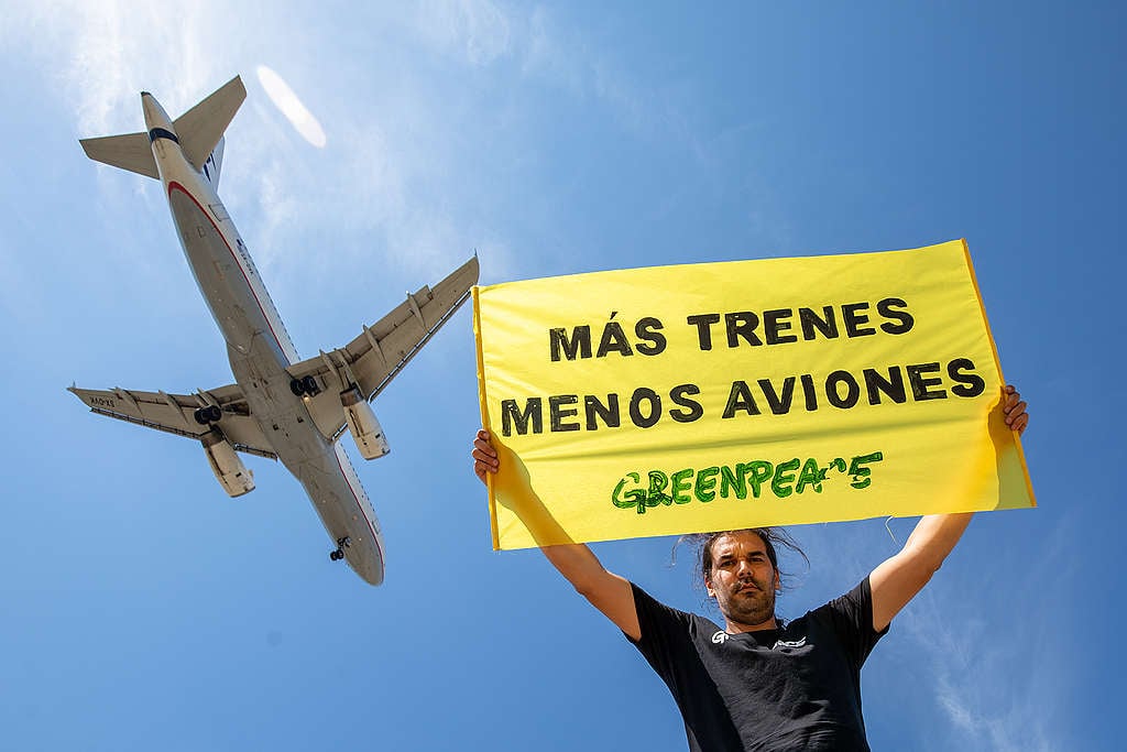 Greenpeace Spain hold a banner that reads: "more trains and fewer planes". © Greenpeace / Pablo Blázquez