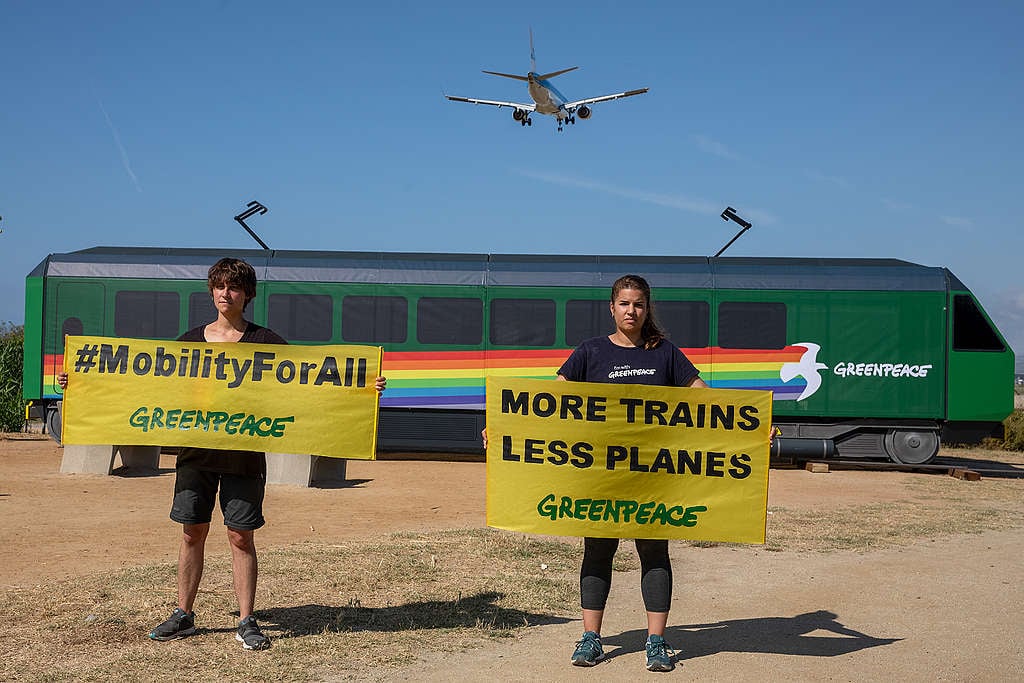 Activists from Greenpeace Spain hold a banner that reads: "more trains and fewer planes". © Greenpeace / Pablo Blázquez