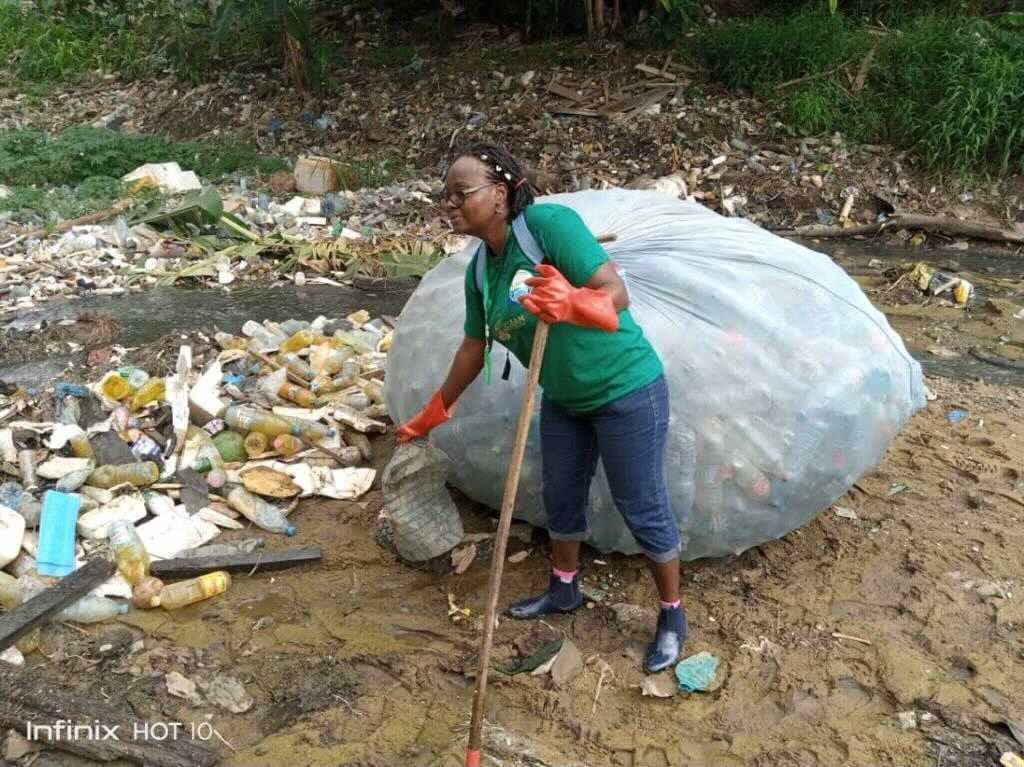 Image showing Nathalie Wamja, a Greenpeace Africa volunteer based in Douala, Cameroon cleaning up plastic and actively fighting against the consequences of plastic pollution and floods.