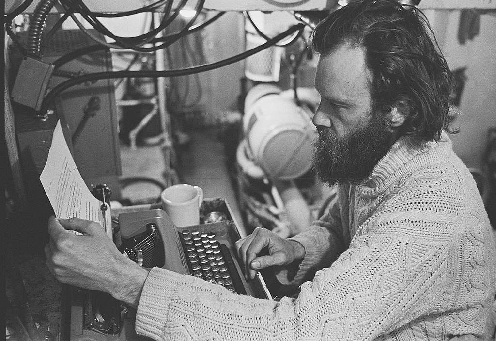 Bob Hunter typing a media release at his engine-room desk, 1976. © Greenpeace / Rex Weyler