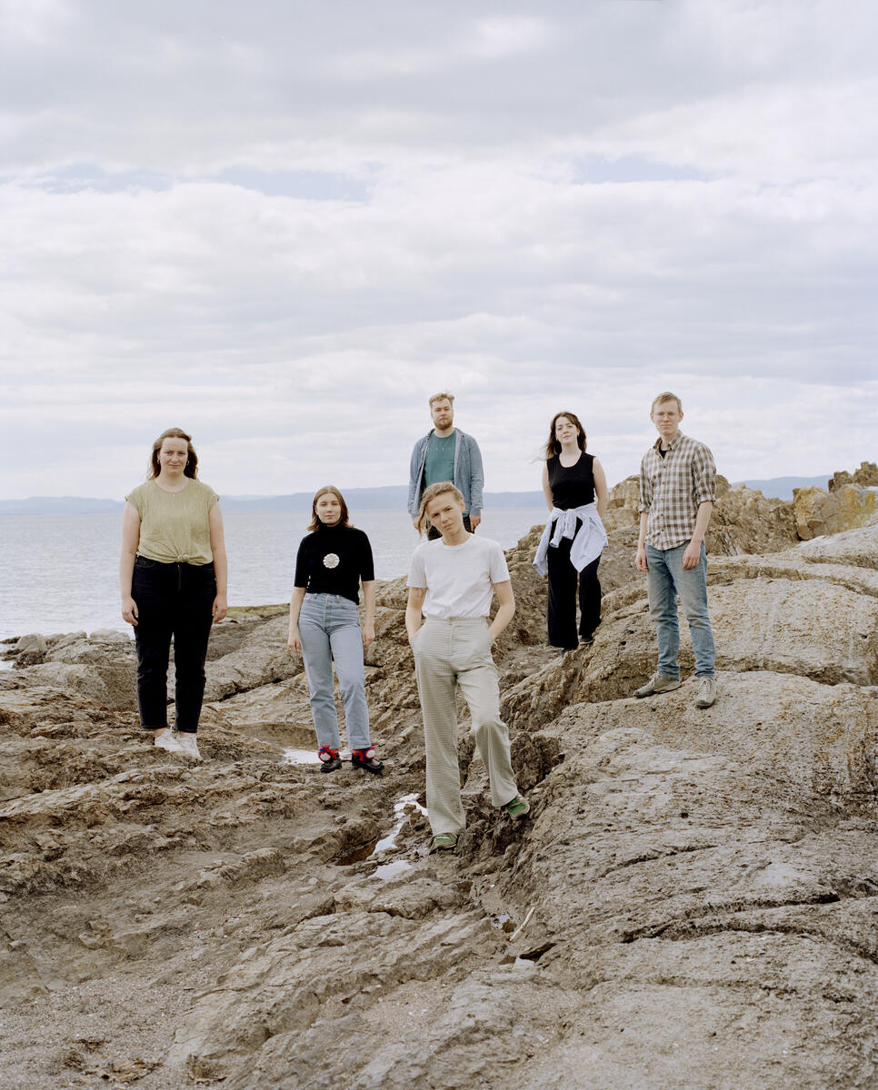 Six young climate activists posing on a rocky shoreline in Norway. © Lasse Fløde / Greenpeace