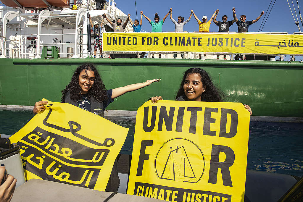 Youth climate champions Alia Hammad from Egypt (right), and Watan Mohammed from Sudan, along with the crew of the Rainbow Warrior, are pictured with banners for United for Climate Justice ship tour, in the Mediterranean Sea near Egypt.