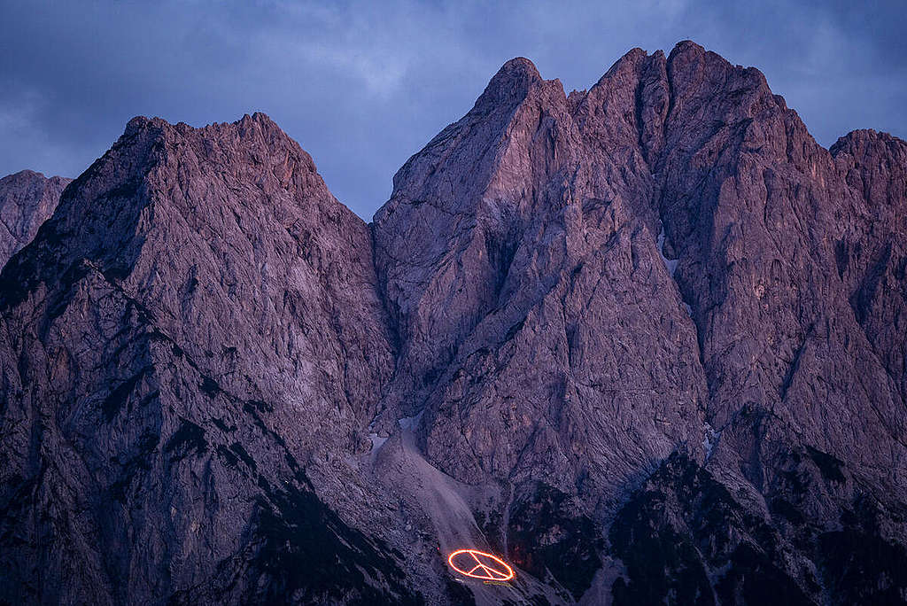 On the occasion of the G7 Summit in Elmau, 10 Greenpeace activists protested at the Waxenstein near Garmisch-Partenkirchen. A mountain bonfire in the shape of a peace sign with a diameter of 60 meters lit on the slope. On banners they demanded: "G7: Exit Fossils, Enter Peace" and "G7: Stop Gas, Oil and Coal Now". Images formed from fire in the mountain peaks are a tradition in the Alpine region for the summer solstice, dating back to the Middle Ages. © Bernd Lauter / Greenpeace