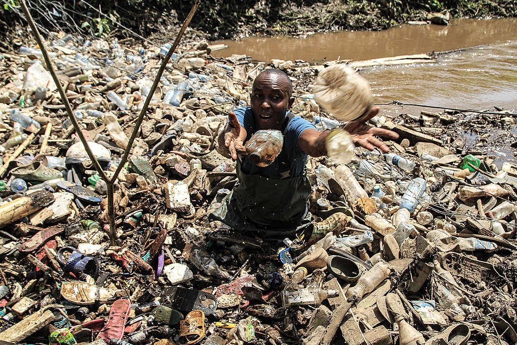 James collecting plastic waste at Njoro River In Nakuru. © Bedan Mwihia