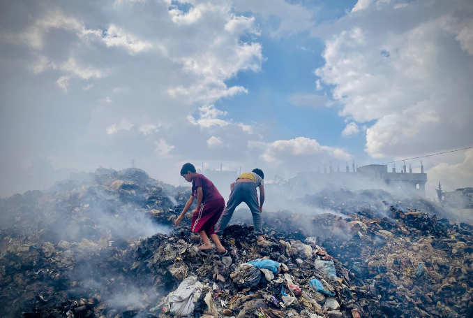 Two children standing on a heap of trash in Gaza. Hundreds of thousands of tons of waste are surrounding the residents in the Gaza Strip. © United Nations Relief and Works Agency for Palestine Refugees in the Near East (UNRWA) Photo: United Nations Relief and Works Agency for Palestine Refugees in the Near East (UNRWA)