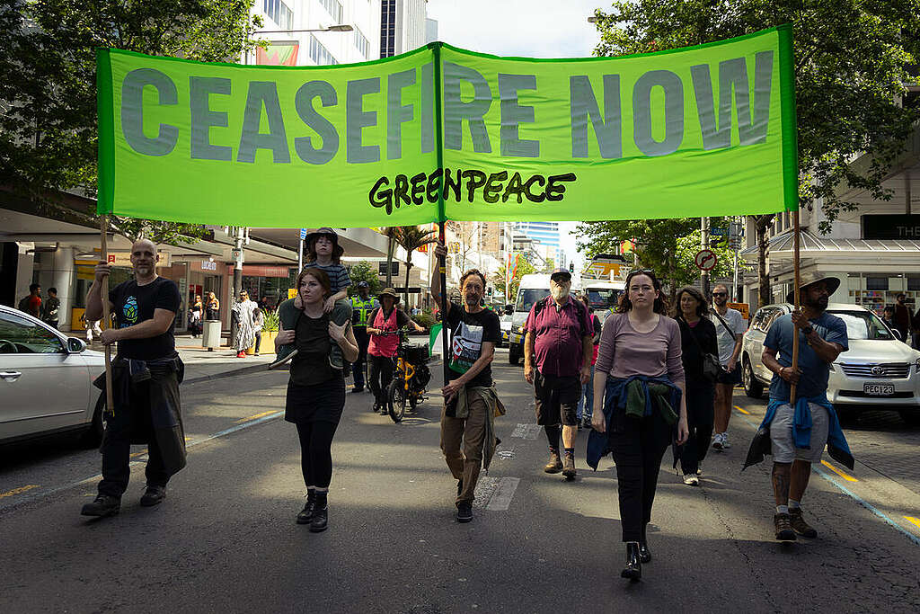 Greenpeace Aotearoa staff with a banner reading "Ceasefire Now" at a march in Auckland, New Zealand, for peace in the Israel/Palestine conflict.