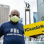 Greenpeace activist  holds a banner reads #CleanAirNow  during an air pollution campaign  in Jakarta.