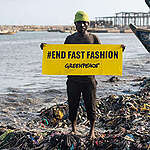 The fashion industry has a massive plastic problem that it outsources to countries in the Global South, where textile waste pollutes the environment. Ghana is one of the world's largest consumers of second-hand textiles. A good 120,000 tonnes of second-hand clothing from Asia, North America and Europe end up in the West African country every year. More than half of the clothing is inferior disposable goods with no resale value - much of it is made of plastic.

On a research trip to Accra, a team from Greenpeace Africa and Greenpeace Germany used infrared scanners to examine discarded clothing at landfill sites and identify the various fibres. The result: almost nine out of ten items of clothing (89 per cent) contain synthetic fibres made from fossil fuels. After the garments are thrown away, these synthetic fibres decompose into microplastics. In the tested clothing from the Kantamanto market - the largest second-hand textile market in West Africa - the figure is as high as 96 per cent.

Greenpeace also analysed the air quality in three wash houses in Accra where textile waste is incinerated. The results show that the air is heavily polluted with hazardous chemicals, many of which are single or multiple carcinogens, mutagens and toxic to reproduction. 

As part of a return-to-sender campaign, Greenpeace shipped textile waste back to Germany in a container designed by Ghanaian artists in order to take further samples and raise awareness about the destructive side of fast fashion. 

Overconsumption in the textile industry and the massive use of synthetic plastic fibres and blended fabrics are causing devastating environmental damage and threatening nature and people in the Global South.

In the picture: Greenpeace banner at Jamestown, a fishery town in Accra where textile waste is washed into the sea