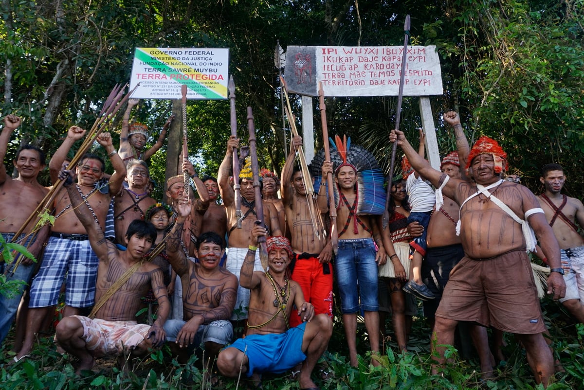 Munduruku People stand in front of signs to self-demarcate their Indigenous Land in the Amazon. © Rogério Assis / Greenpeace