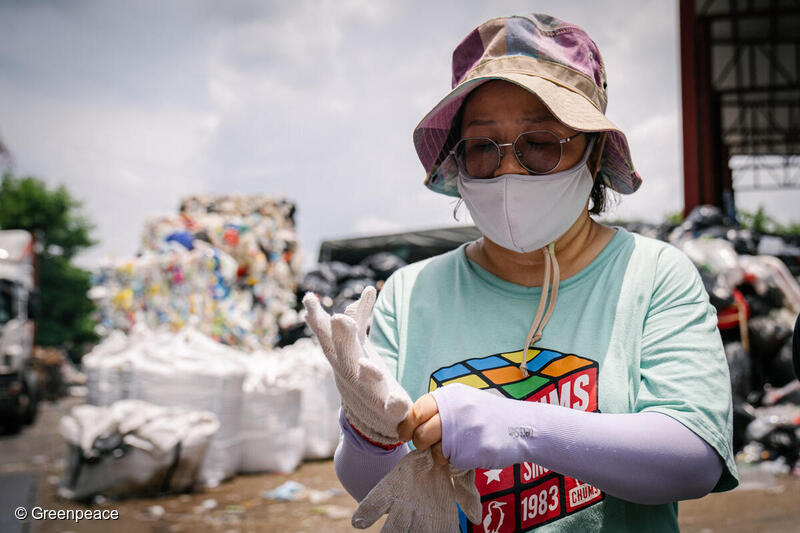 香港のプラスチックリサイクル工場で手袋をしてプラスチックの選別作業をするボランティア。