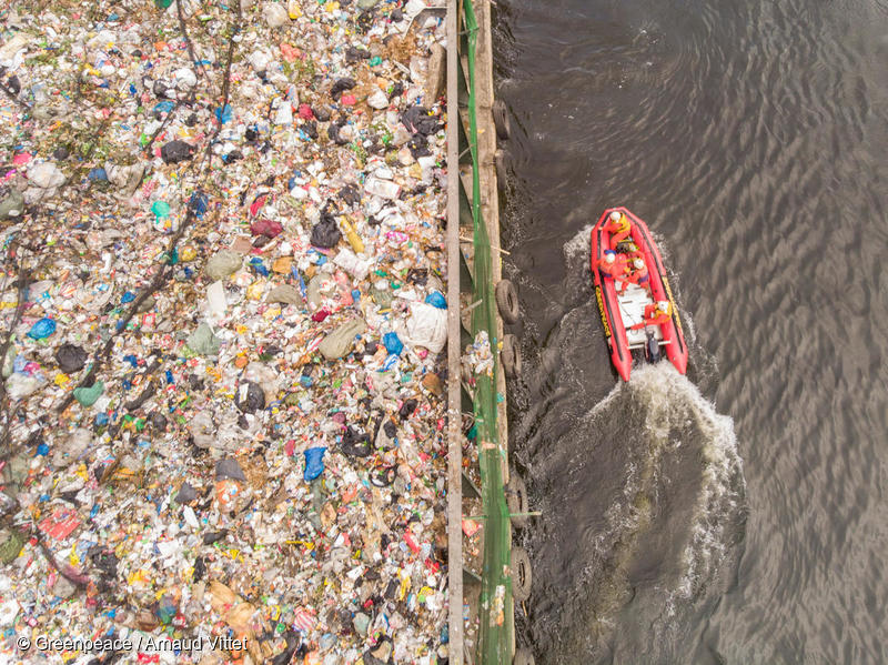 マニラ湾を通過する大量のプラスチック廃棄物を積んだ船と抗議活動を行うグリーンピース