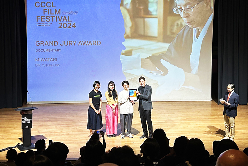 ステージでCCCL映画祭の創設者クリストファー・G・ムーア氏から審査員大賞の盾を受け取るグリーンピース・ジャパンとHAKUAのメンバー