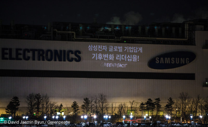 그린피스 활동가들이 2018년 2월, 삼성 기흥 반도체 공장 위에 100% 재생가능에너지 사용을 촉구하는 문구를 프로젝션으로 쏘고 있다.