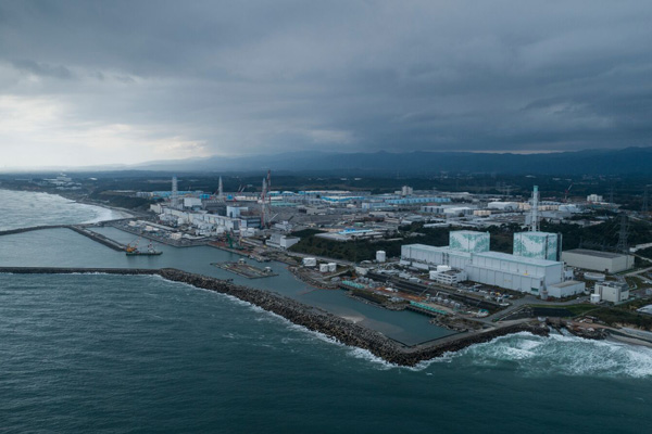 그린피스가 지난해 10월17일 공중 촬영한 후쿠시마 원전 전경. 사진 왼쪽(남쪽)에 후쿠시마 원자로 1~4호기가 있고 오른쪽(북쪽)에 5~6호기가 자리한다. 서쪽과 남쪽에 자리한 후타바와 오쿠마 마을은 접근과 거주가 제한됐다. 사진 뒤쪽으로 푸른색 구조물처럼 보이는 방사성 오염수 저장탱크 944개가 줄지어 늘어서 있다