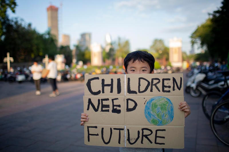 기후위기 해결을 촉구하는 피켓을 들고 있는 어린아이