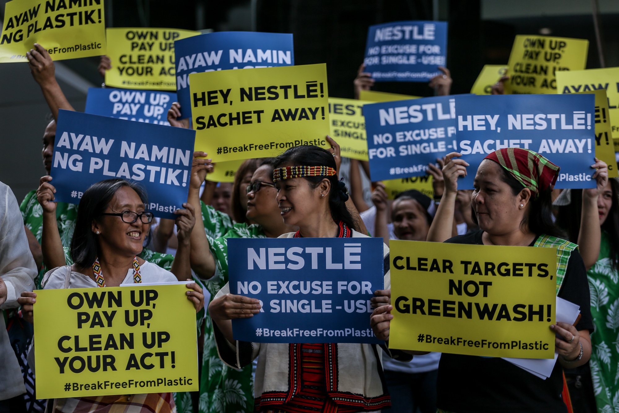 필리핀 네슬레 본사앞에서 플라스틱 오염의 책임을 강조하는 배너를 들고 있는 환경운동가들