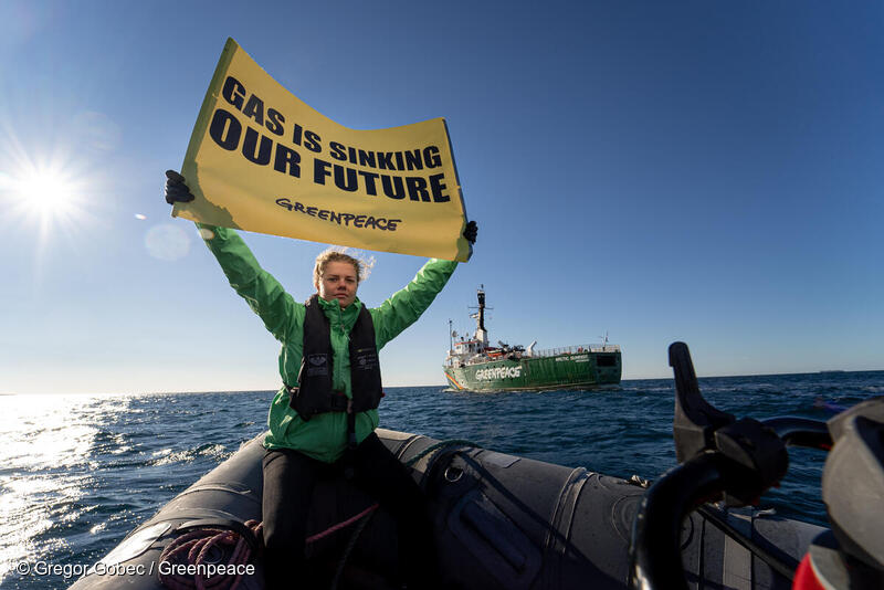 그린피스 활동가가 화석 가스인 LNG를 멈추라는 배너를 들고 있다.