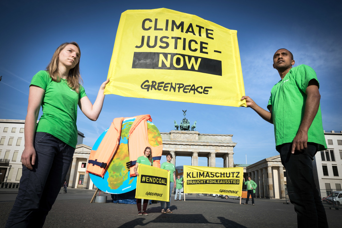Les militants de Greenpeace présentent un disque de quatre mètres, représentant le monde entier, portant un gilet de sauvetage à la place Pariser à Berlin.