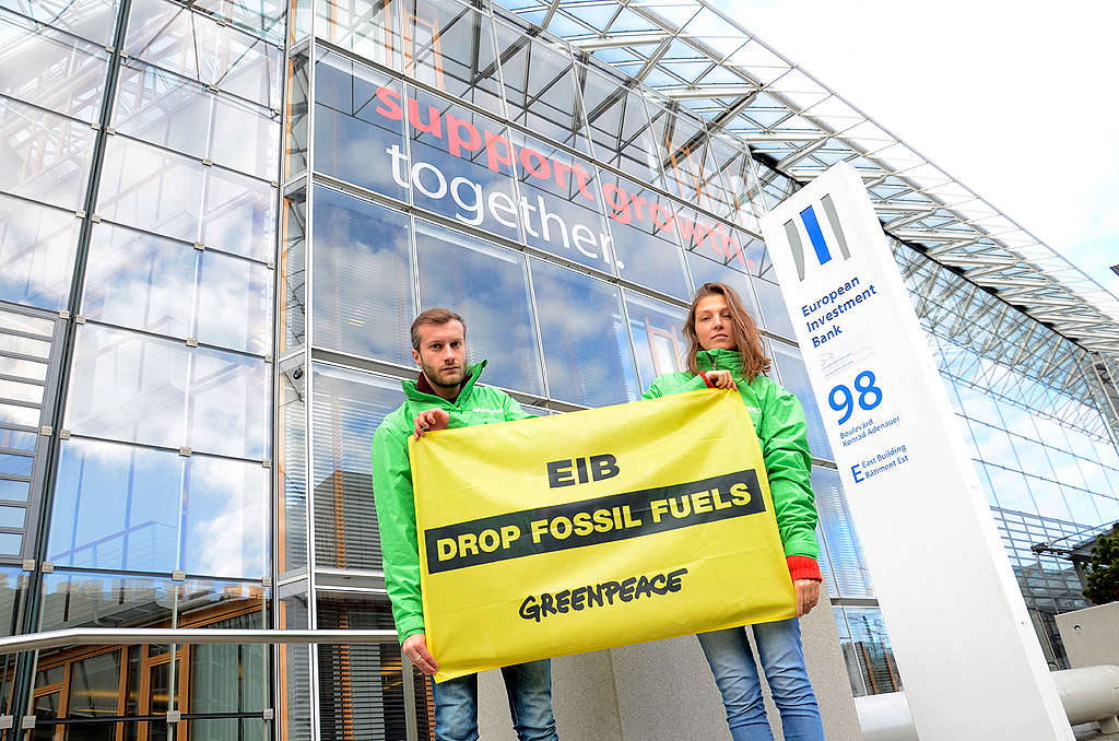 Aktivisten stehen vor dem EIB-Gebäude in Luxemburg. Sie halten ein Banner, das die EIB auffordert, die Investitionen in fossile Brennstoffe einzustellen.