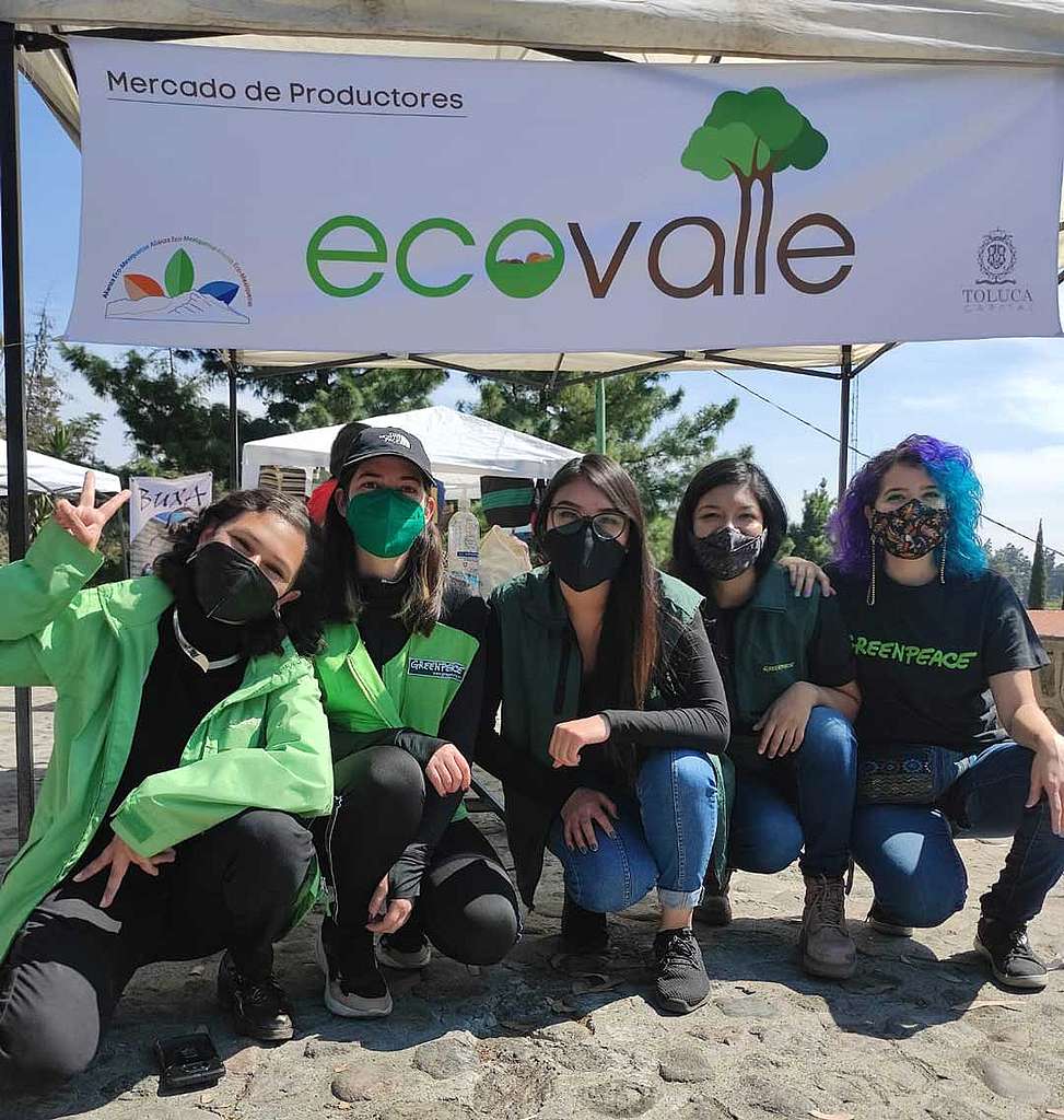 Voluntarias de Greenpeace México frente a un letrero de Mercado de productores “Ecovalle”