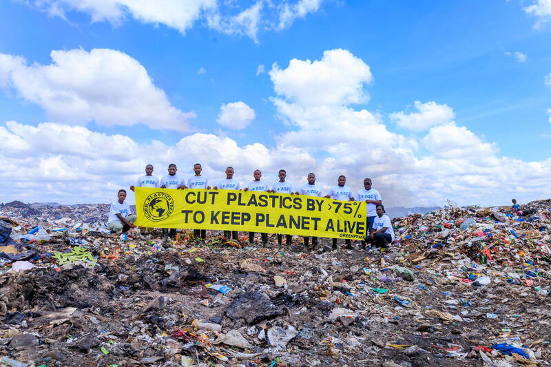 Pancarta en el vertedero de Dondora, Kenia - Voluntarios de Greenpeace África con una pancarta en la que se lee "Reducir los plásticos en un 75% para mantener vivo el planeta", en el corazón del vertedero de Dandora.