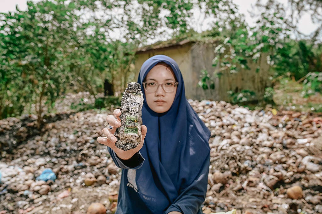 Laras Nauna, científica marina y organizadora local contra los residuos plásticos en su comunidad. Laras sostiene una botella de Dove desechada durante una limpieza de playa con la comunidad de Sahabat Laut.