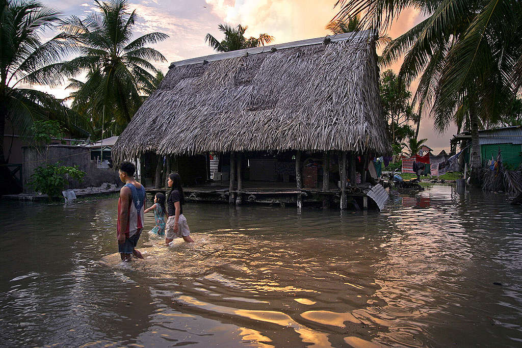 Inwoners van Tuvalu lopen door overstroomde straten.