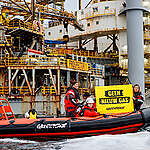 Actievoerders Greenpeace protesteren met rubberboten tegen gasboringen boven Schiermonnikoog