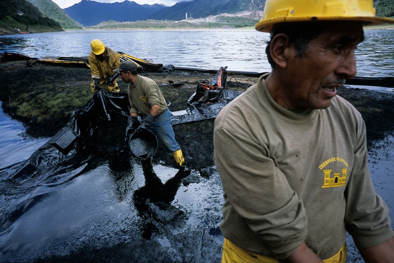 Llokalbefolkning i Andesfjellene rtdder opp etter et oljeutslipp nær byen Papallacta i 2003.