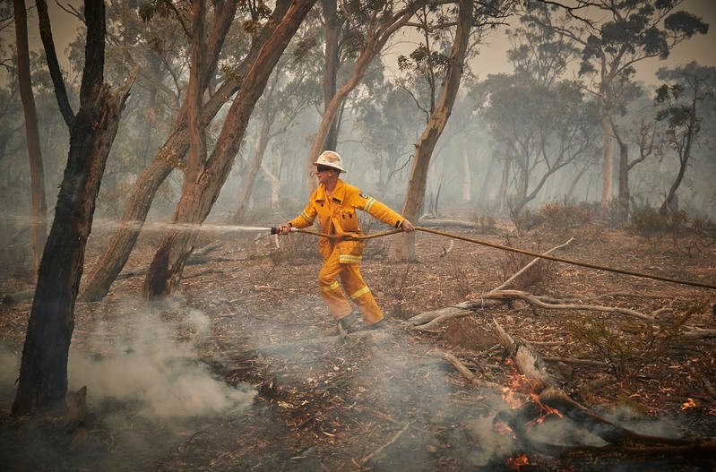 Mark Bennett løpet gjennom skogen for å kunne nå flammene i Numeralla, Australia. Mark er 70 år og har vært frivillig brannslukker i 46.