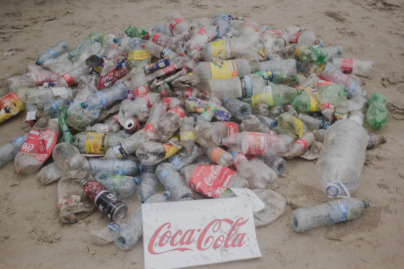 Opprydning og rapportering av plastavfall i regi av Greenpeace på stranden Miramar i Mexico. På skiltet står det Coca-Cola.