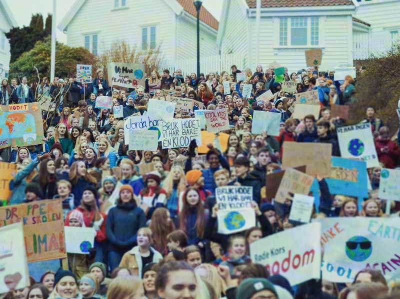 En stor folkemengde med barn og unge som deltar i en skolestreik for klimaet. De holder opp en rekke protestskilt med slagord som "Bruk hodet, vi har bare en klode". Bildet er hentet fra Equinors reklamefilm "Takk for de første 50".