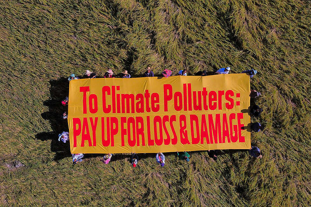 Demonstrasjon blant bønder etter tyfonen Noru på Filippinene. Banner sier: "To climate polluters: Pay up for loss and damage".