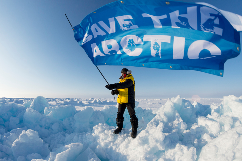 Renny Bijoux fra Seychellene, en arktisk ambassadør med Nordpolens ekspedisjonsteam, vinker med en
'Save the Arctic' banner ved ankomst til Nordpolen. 