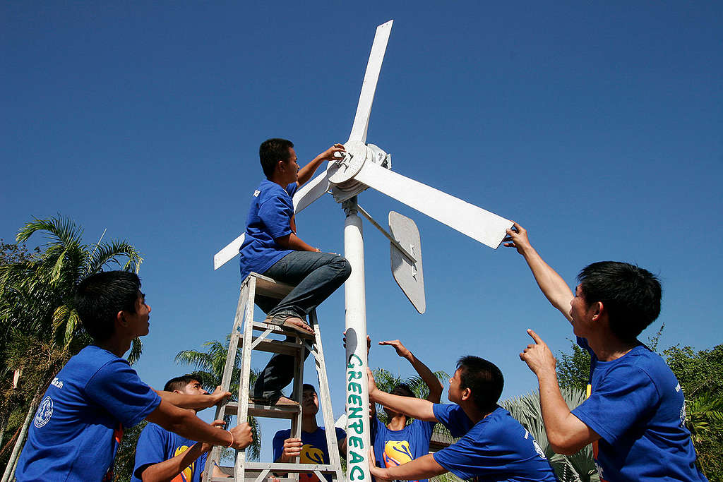 Ungdommer setter opp en vindturbin i Thailand. 