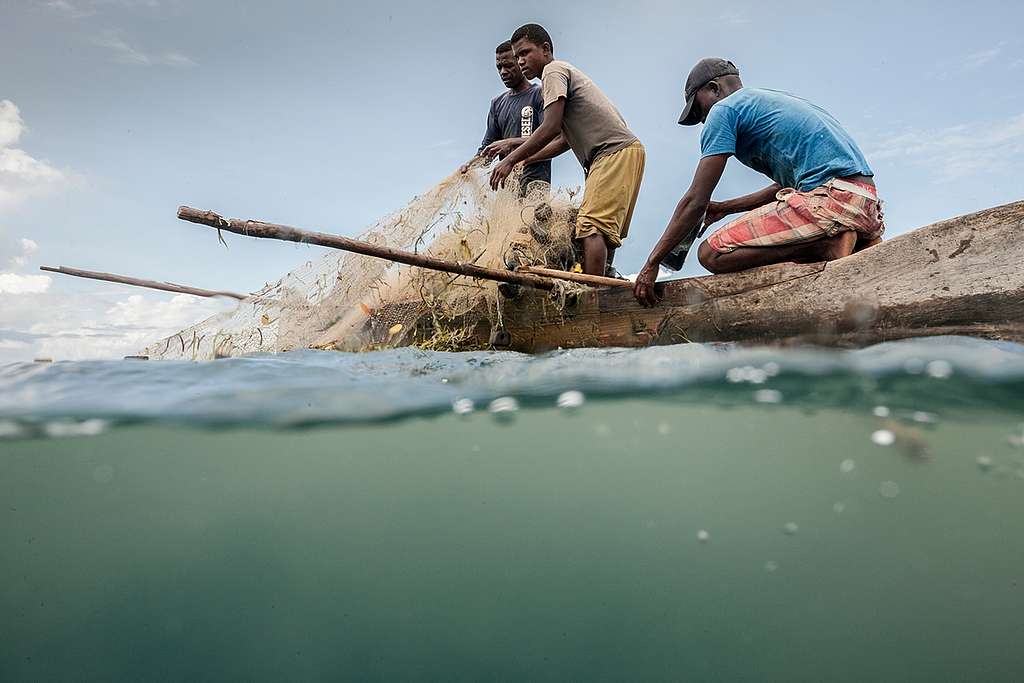 Fiskere trekker opp et garn på en tradisjonell trekano ved øya Nosy-Be utenfor Madagaskar.