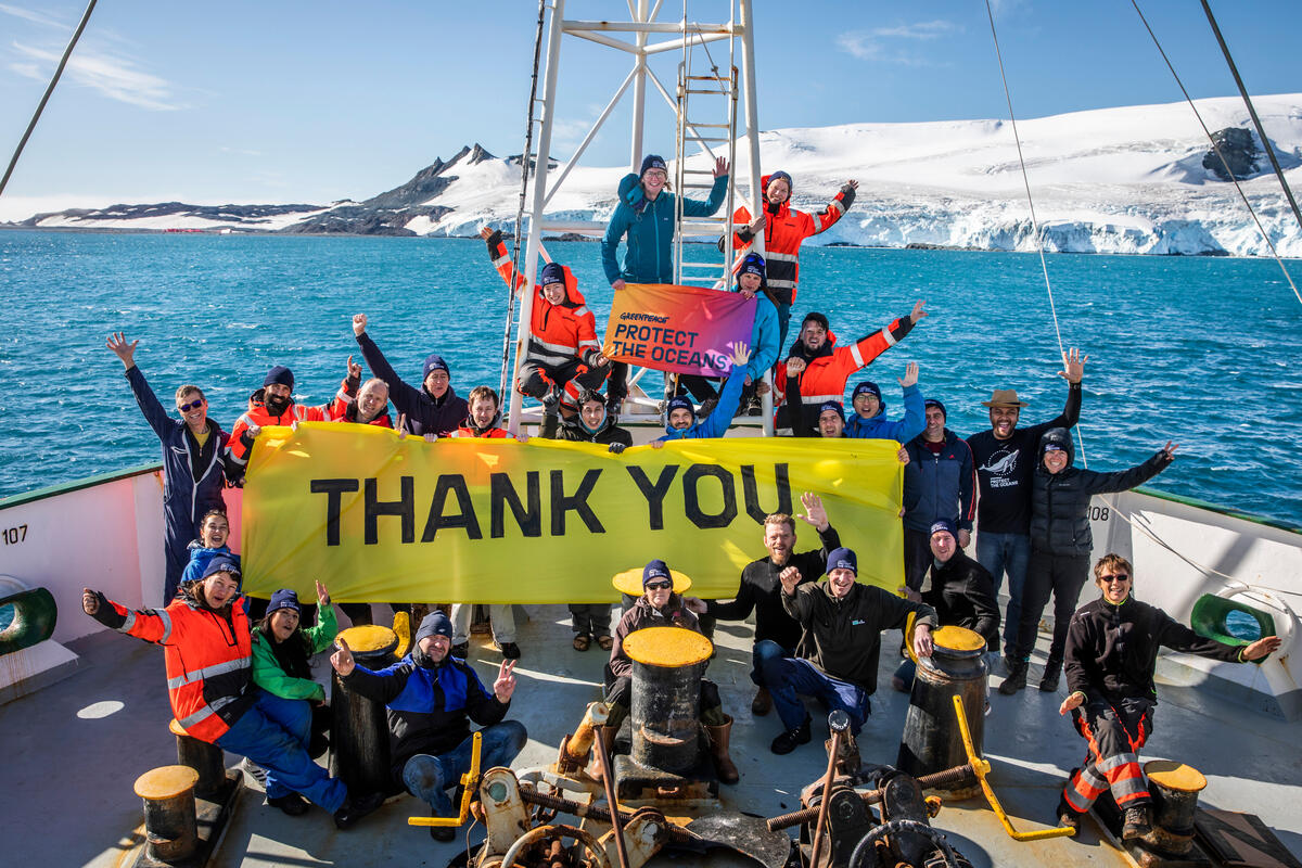 Mannskapet på Greenpeace-skipet Esperanza under skipsturen i Antarktis, med et banner som sier "thank you", "takk". © Andrew McConnell / Greenpeace