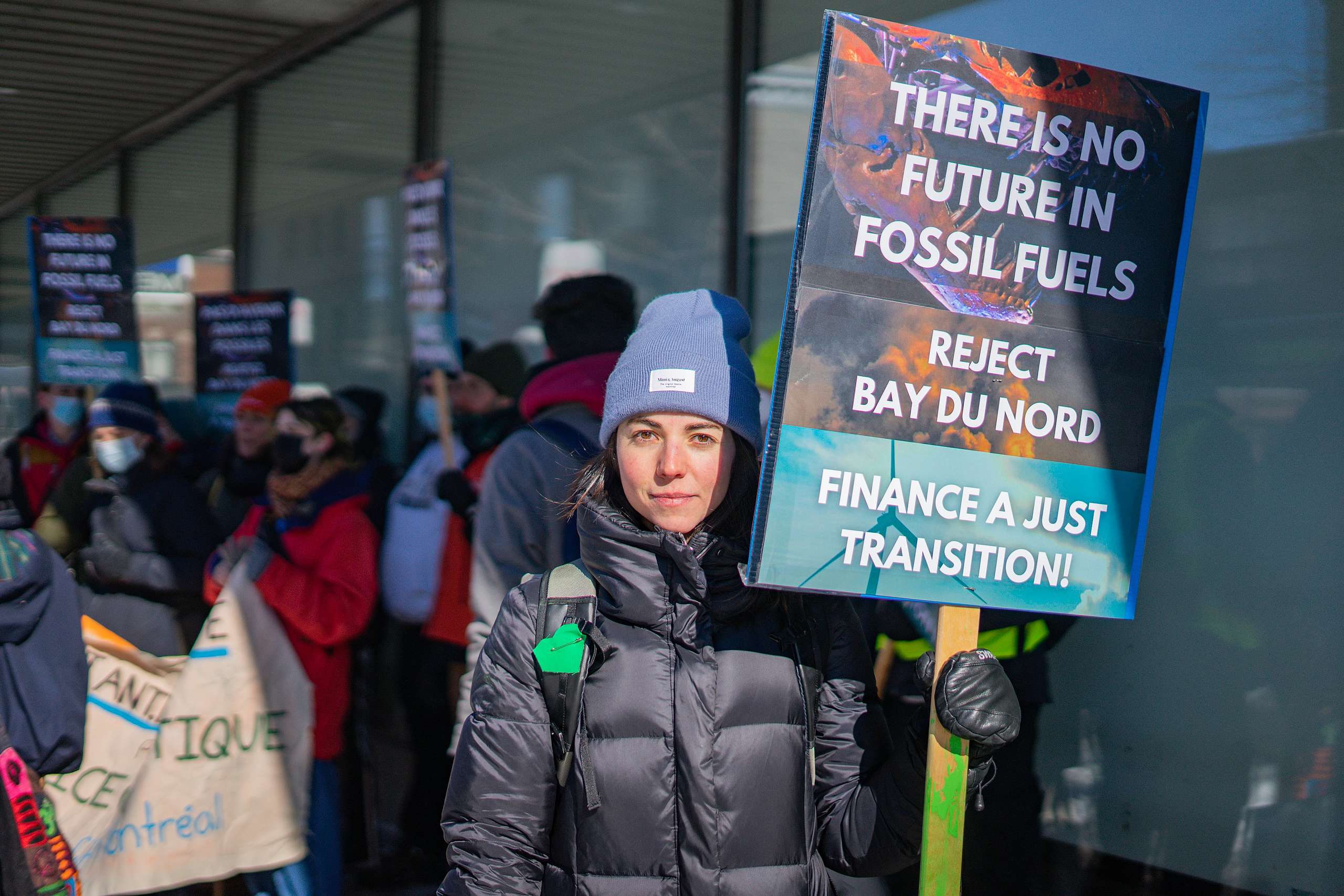 Aktivist holder et skilt med teksten 'There is no future in fossil fuels. Reject Bay Du nord. Finance a just transition'.