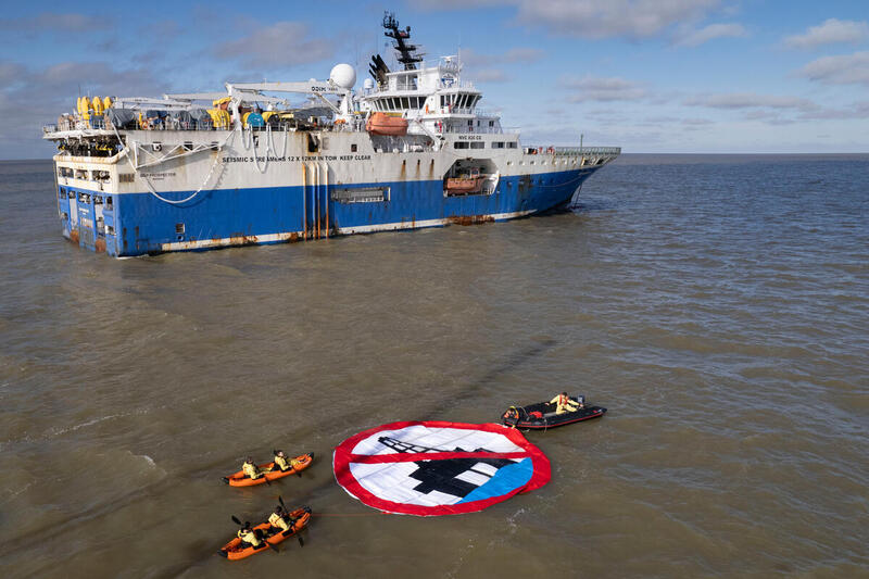 Seks Greenpeace aktivister om bord skipet Witness ruller ut et ni-meter langt flytende banner foran et seismikkskip i protest mot Equinors oljeleting i Argentinahavet. 