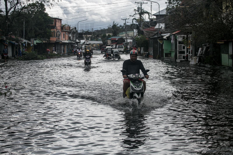 Bilister vasser gjennom en oversvømt gate på grunn av tyfonen Tisoy i Legazpi City i provinsen Albay, Filippinene. Tyfonen Kammuri brakte kraftig regn og sterk vind da den kom til land mandag kveld i Sorsogon-provinsen.