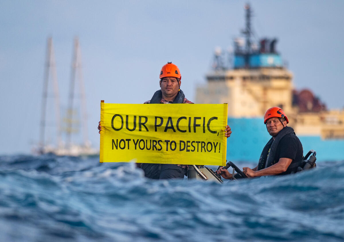 En Greenpeace-aktivist fra Fiji viser et banner med teksten «Our Pacific Is Not Yours To Destroy» under en protest mot gruvedrift på havbunnen i Stillehavet. 