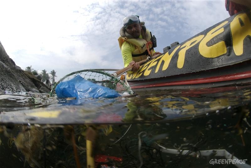 Greenpeace volunteers collect plastic rubbish from Manila Bay. Once a beauty spot it has now become one of the most polluted bodies of water in Asia where sludge, human waste and industrial waste have formed a floating dump.
