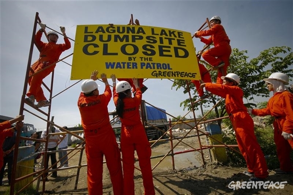 August 2008: Greenpeace Water Patrol activists construct a metallic barrier at the entrance to a waste dump in Angono.