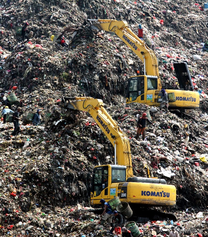Scavengers collecting garbage surround the excavators at the Bantar Gebang dump site in Bekasi, West Java on Nov 22, 2016. 