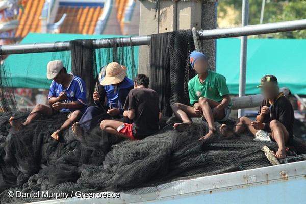 Burmese workers repair nets aboard a Thai purse seiner docked in Samut Sakhon, central Thailand.