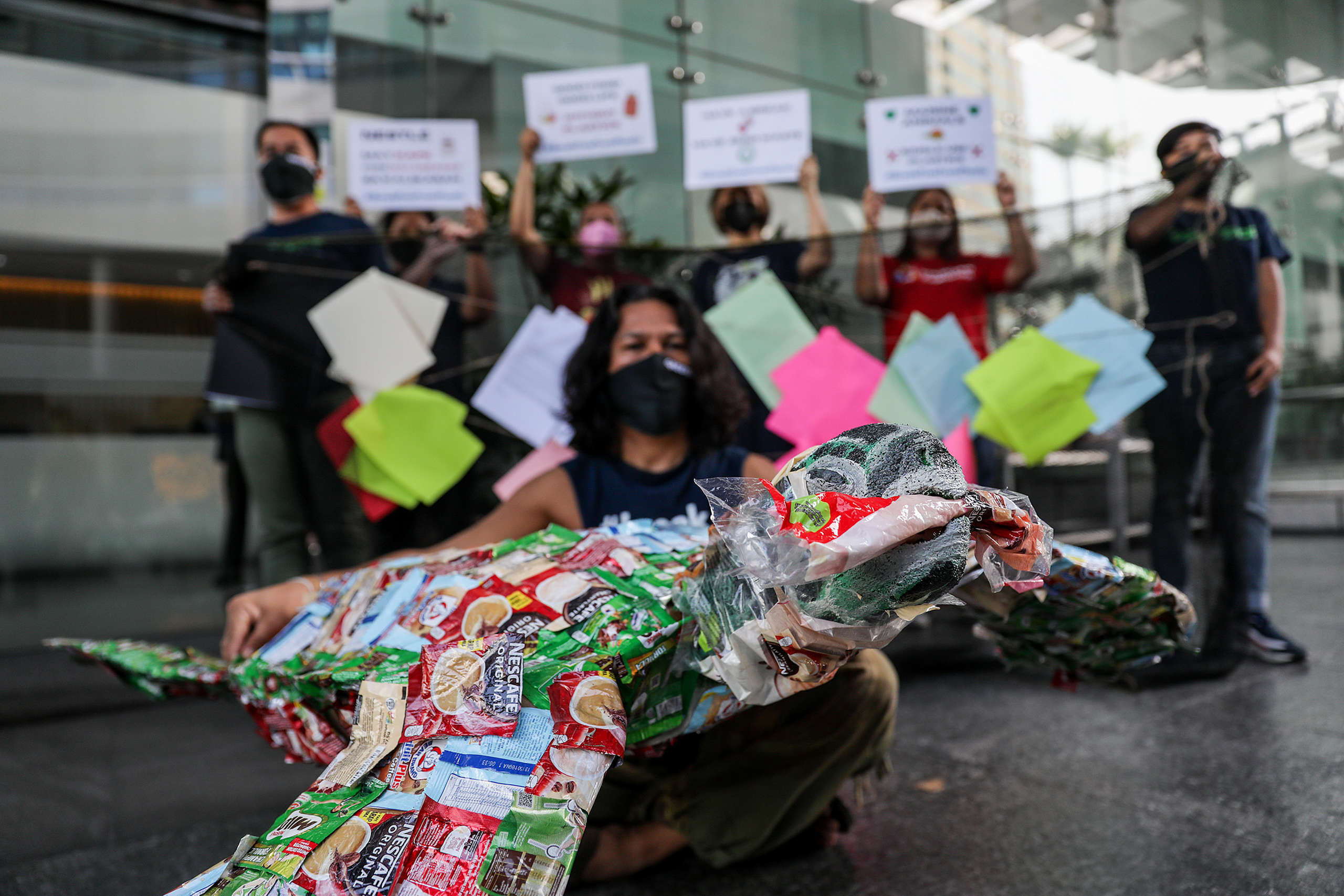 Members of Greenpeace Philippines and the Break Free From Plastic movement deliver a sea turtle made of plastic packaging waste during a protest at the Nestle headquarters in Rockwell Center, Makati.