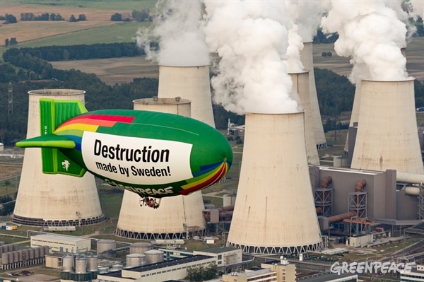 Hot air balloon with message over coal power plant