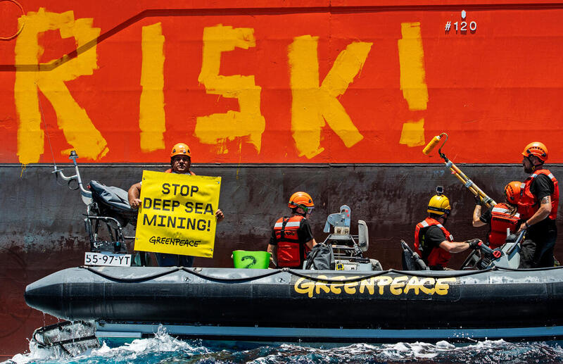 Aktivister i gummibåt håller upp banner som säger stop deep sea mining