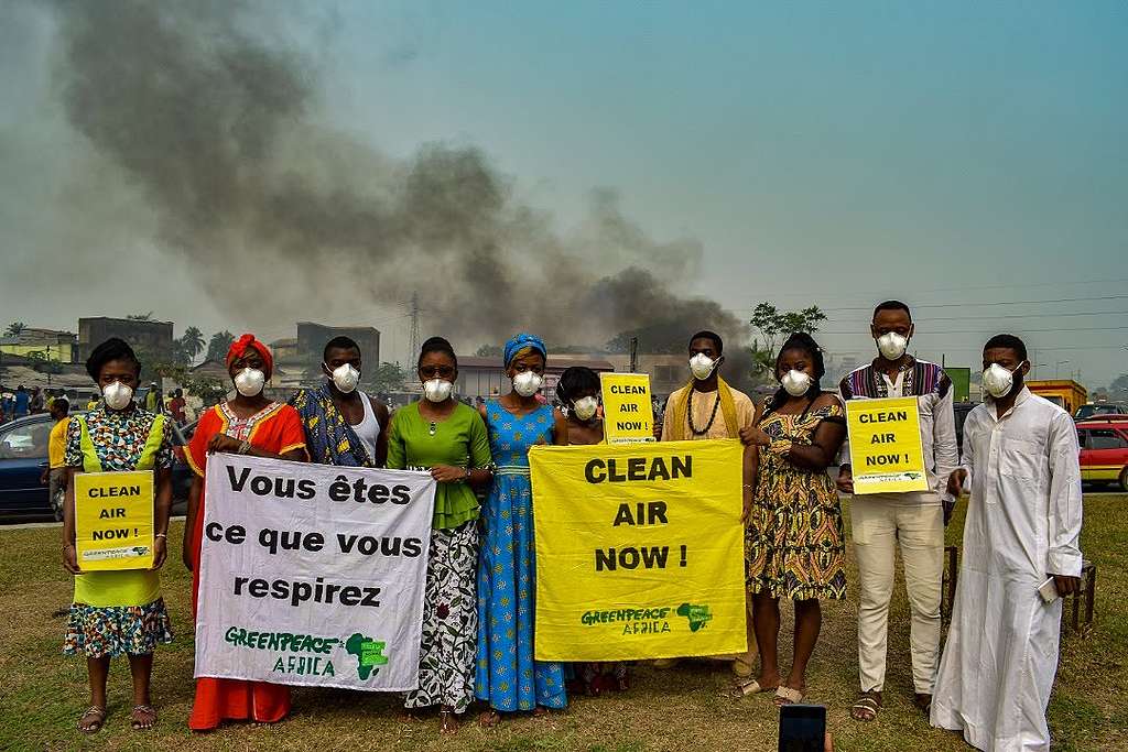 喀麥隆行動者於當地燃煤電廠前，手持「我要乾淨空氣！」的標語，背後黑煙瀰漫，問題的嚴重程度不言而喻。