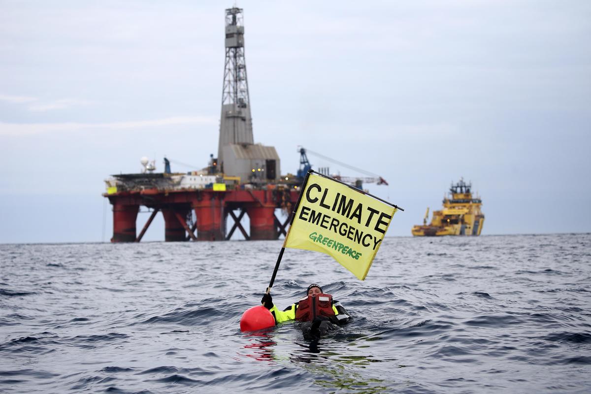 2019年綠色和平行動者於英國石油公司在北海上的鑽油臺前，手舉「氣候緊急」旗幟，要求停止進行新的鑽油計畫，轉向發展再生能源，減緩氣候變遷。